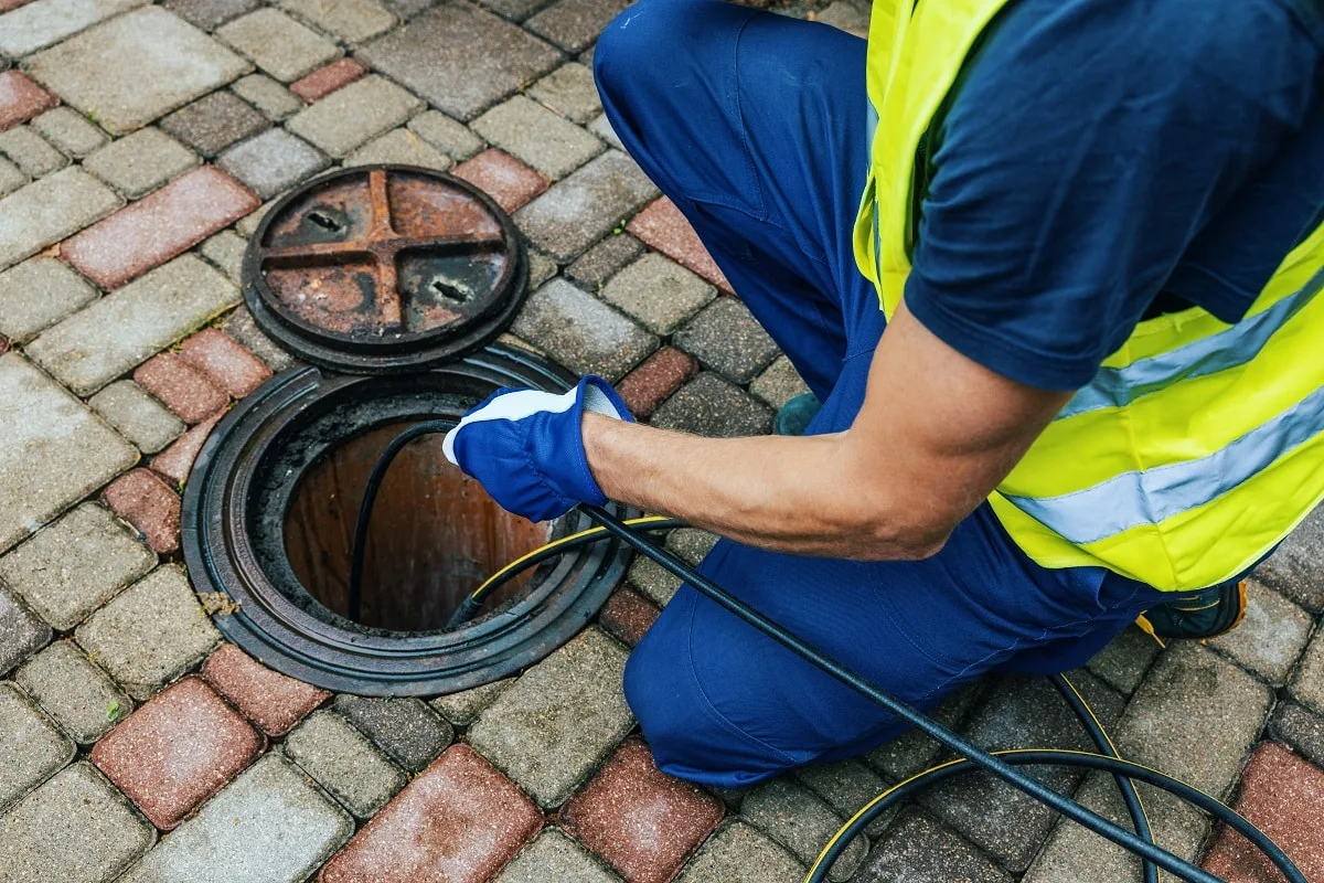 Technician clearing a sewer and drain line